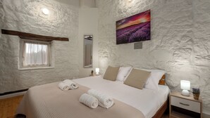 A bedroom with a large bed, a nightstand with a lamp, a window with curtains, a painting on the wall, and a mirror. - Casa Lampadina with pool  for 4-6 persons, located near Porec. Pets are welcome. (Vižinada)