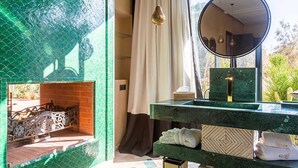 A bathroom with a green tiled wall, a mirror, a sink, and a towel rack. - Villa Dihya pool and jacuzzi - My Rental Homes (Marrakesh)