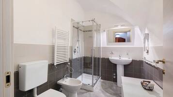 Un bagno con WC, bidet, doccia e lavandino.