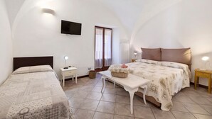 A bedroom with a bed, bedside tables, a TV, and a window. - Duke Room in Pietra Ligure Castle (Pietra Ligure)