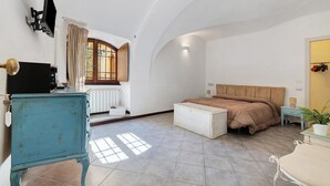 A bedroom with a bed, bedside table, dresser, and a window with curtains. - Marchese Room with Shared Terrace (Pietra Ligure)