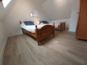 A bedroom with two wooden beds, a skylight, and a wooden wardrobe. - Gîte sleeps 20 with swimming pool and large grounds (Languidic)