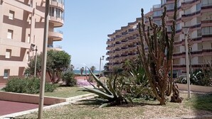 A multi-story residential building with balconies, a landscaped garden with cacti, and a clear view of the sea. - Mar Playa y Sol (Canet-en-Roussillon)