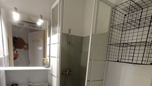 A bathroom with a sink, mirror, shower enclosure, and a wooden rack. - Mar Playa y Sol (Canet-en-Roussillon)