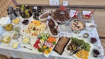 A buffet table with various food items and condiments.