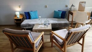 A room with a sofa, two armchairs, a small table, and a lamp. - Hotel Chytrov (Volfířov)