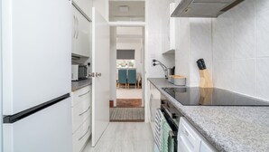 Une cuisine moderne avec des meubles blancs, un four à micro-ondes et une cuisinière.