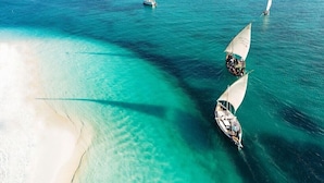 Una playa con aguas turquesas cristalinas y barcos.