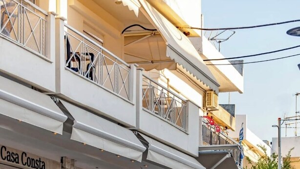 A cafe bar with outdoor seating, a staircase, and a sign for 'Casa Consta.'