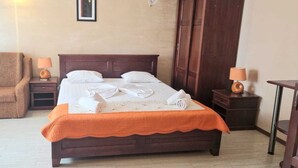 A hotel room with a bed, a sofa, two bedside tables with lamps, and a wooden wardrobe. - Naparis Boutique  (Eforie Sud)