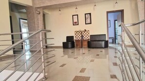 A modern lobby with a glass railing, a seating area, and a door leading to another room. - Naparis Boutique  (Eforie Sud)