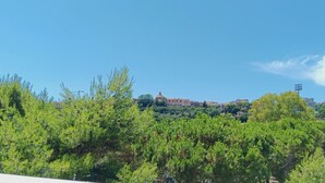 Una vista d'un edifici amb cúpula, envoltat de vegetació i cel blau.