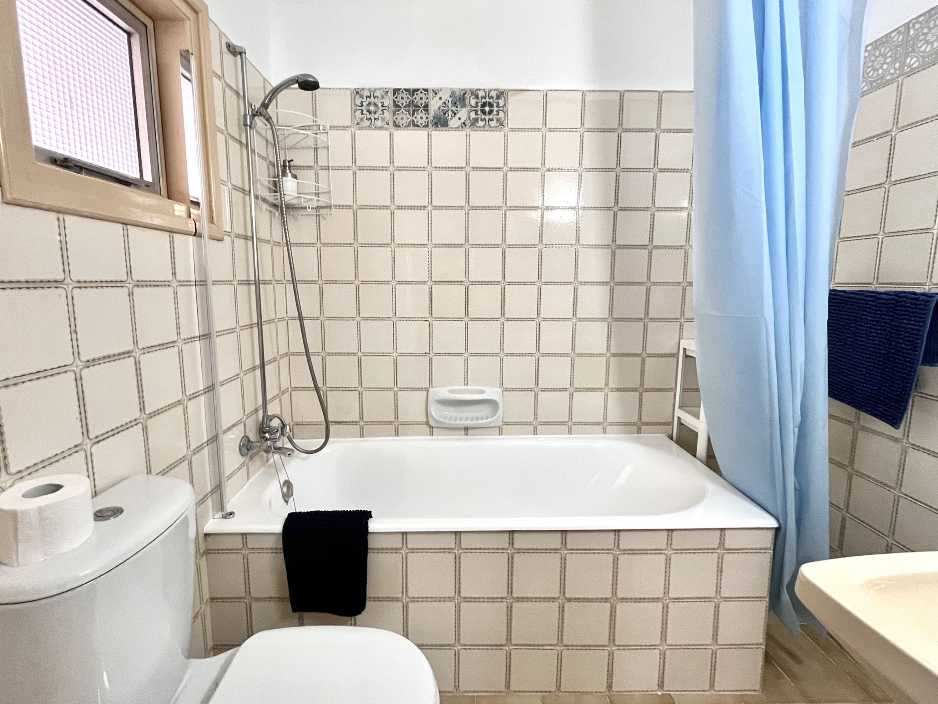 A bathroom with a bathtub, toilet, and shower.