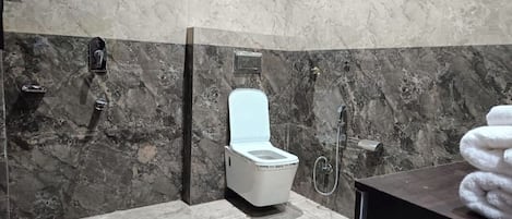 A bathroom with a toilet, shower, and towel rack.