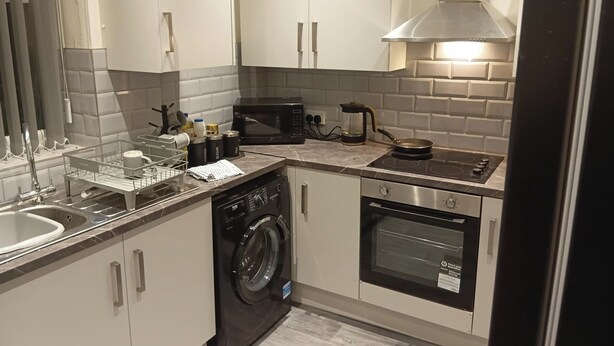 A compact kitchen with a dishwasher, microwave, stove, oven, and a coffee maker. - Dale Combe, 3 Bedroom House 5 Star on air bnb (Manchester)
