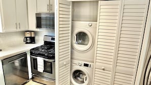 A compact kitchen with a stove, oven, and coffee maker. - Walk to Beach, Tropical Patio, World Cup, Sleeps 5 (Long Beach)