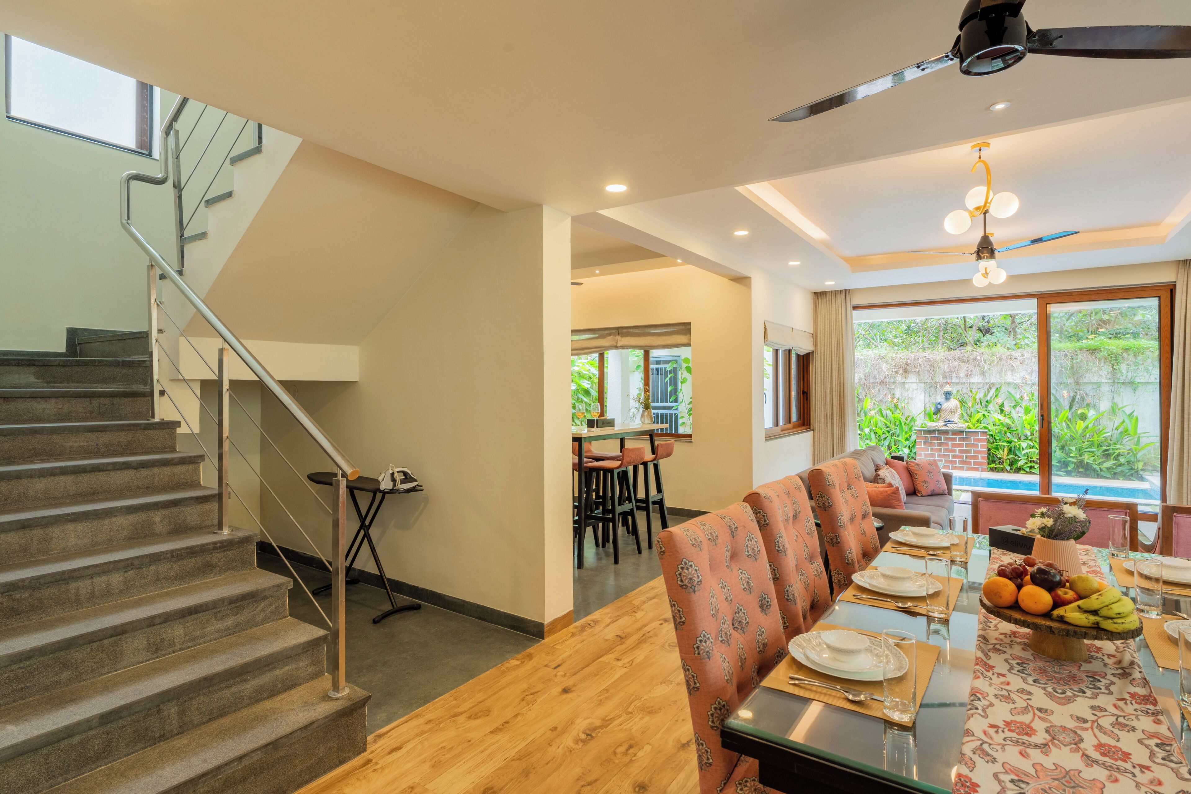 Un espace repas comprenant une table en bois, des chaises et un escalier.