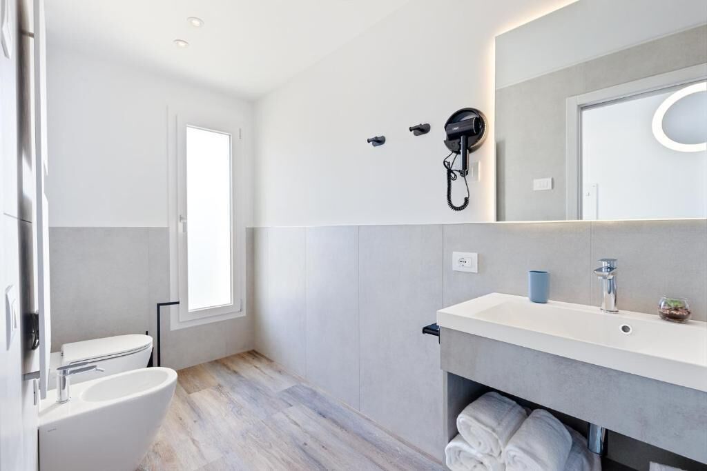Ein modernes Badezimmer mit Toilette, Waschbecken und Dusche.