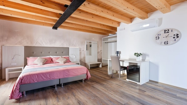 Un dormitorio moderno con cama, mesitas de noche, escritorio y un reloj en la pared.