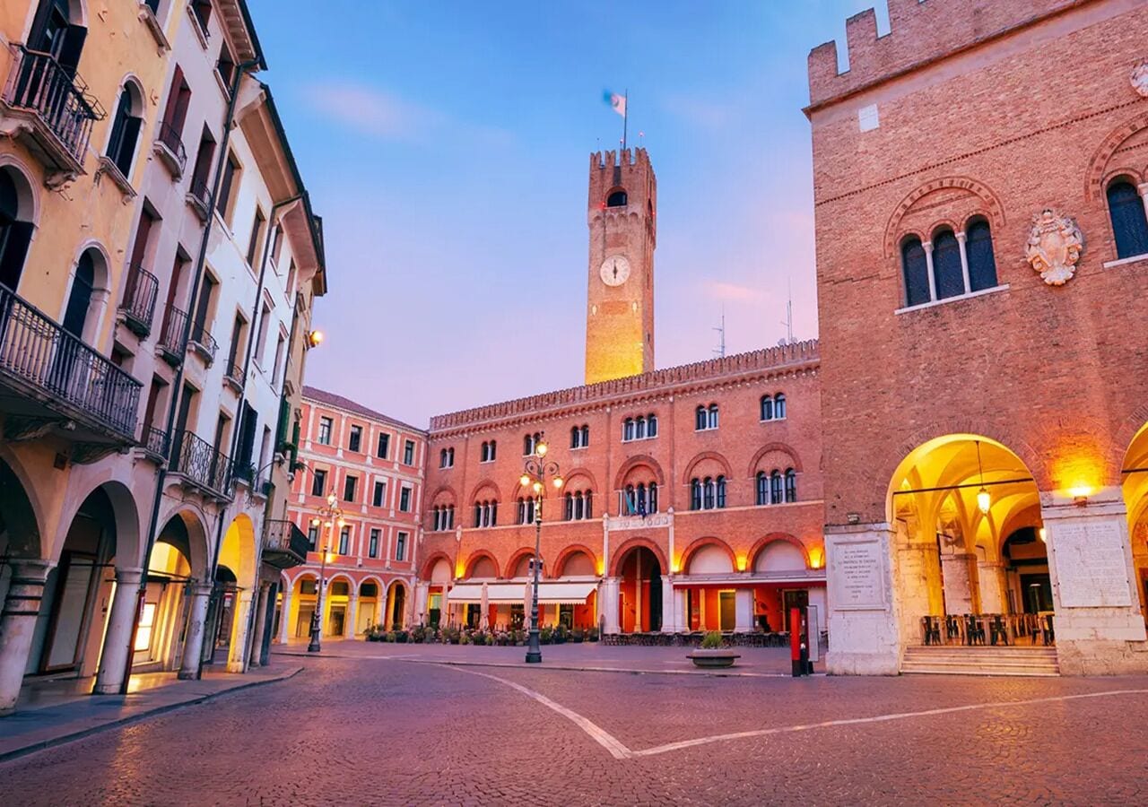 A historic building with a clock tower, arched windows, and a courtyard.