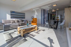 A modern living room with a sofa, coffee table, and dining area. - Fantastic luxury apartment with private whirlpool (Crikvenica)