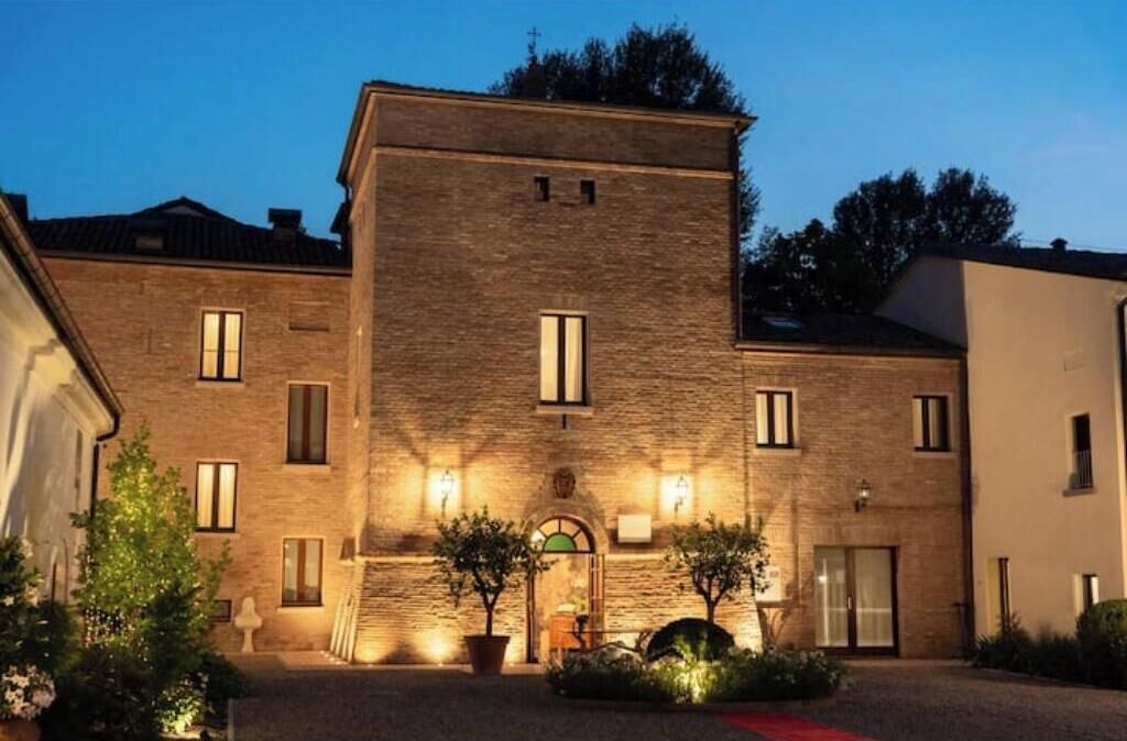 Un immeuble à plusieurs étages, doté d’une façade en briques, de nombreuses fenêtres et d’une entrée centrale avec une porte.