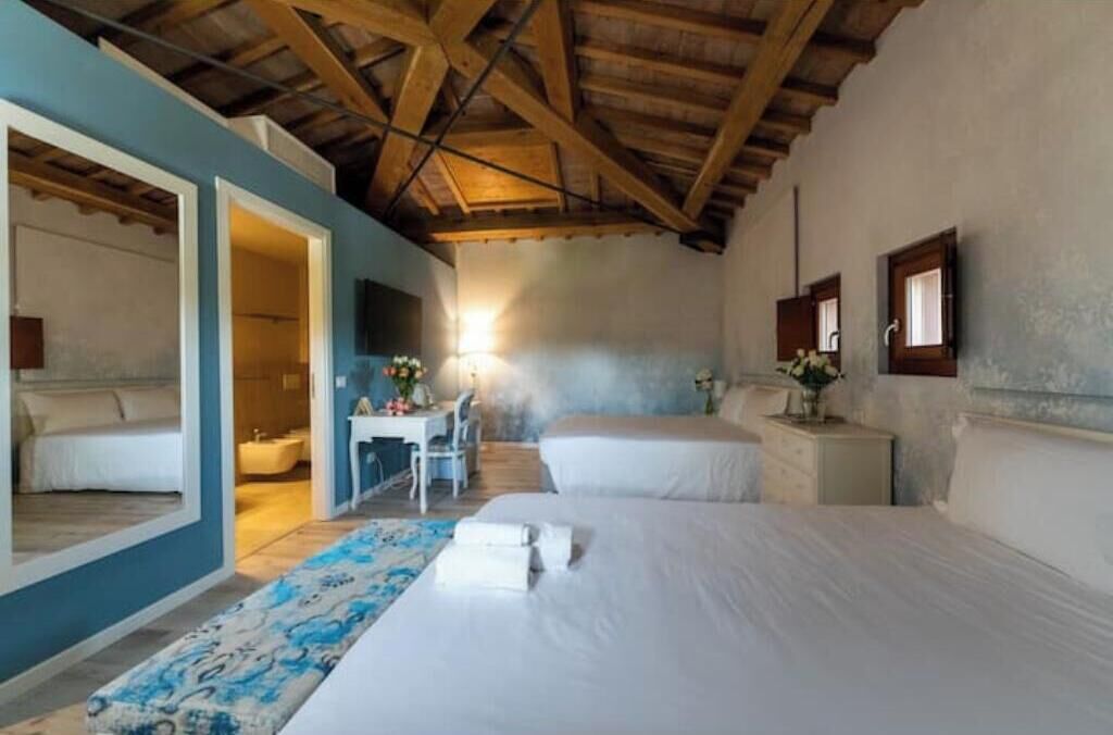 Een slaapkamer met twee bedden, een bureau en een badkamer.