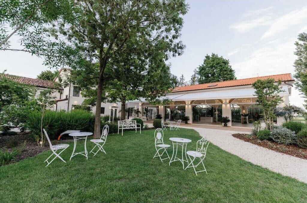 A courtyard with outdoor seating, a building entrance, and a tree.