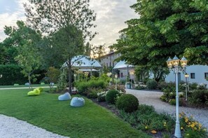 Un jardin avec un sentier, une pelouse verdoyante et un espace salon extérieur.