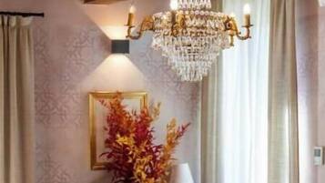 Ein Raum mit einer Chandelier, zwei Sofas, einem kleinen Tisch und einer Zierurne.