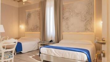 Ein Hotelzimmer mit zwei Betten, einem Schreibtisch, einem Sessel und einer Deckenleuchte.