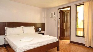 A hotel room with a bed, a nightstand, a window, and a door leading to an outdoor area. - Palette Boracay Isle by The White Beach (Boracay Island)
