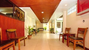 A hallway with wooden benches, potted plants, and a red wall. - Palette Boracay Isle by The White Beach (Boracay Island)