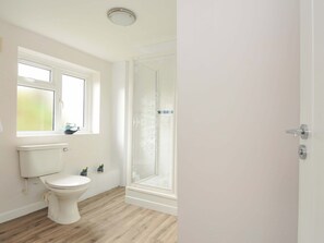 A bathroom with a toilet, a window, and a shower. - Casa Mia (St Austell)