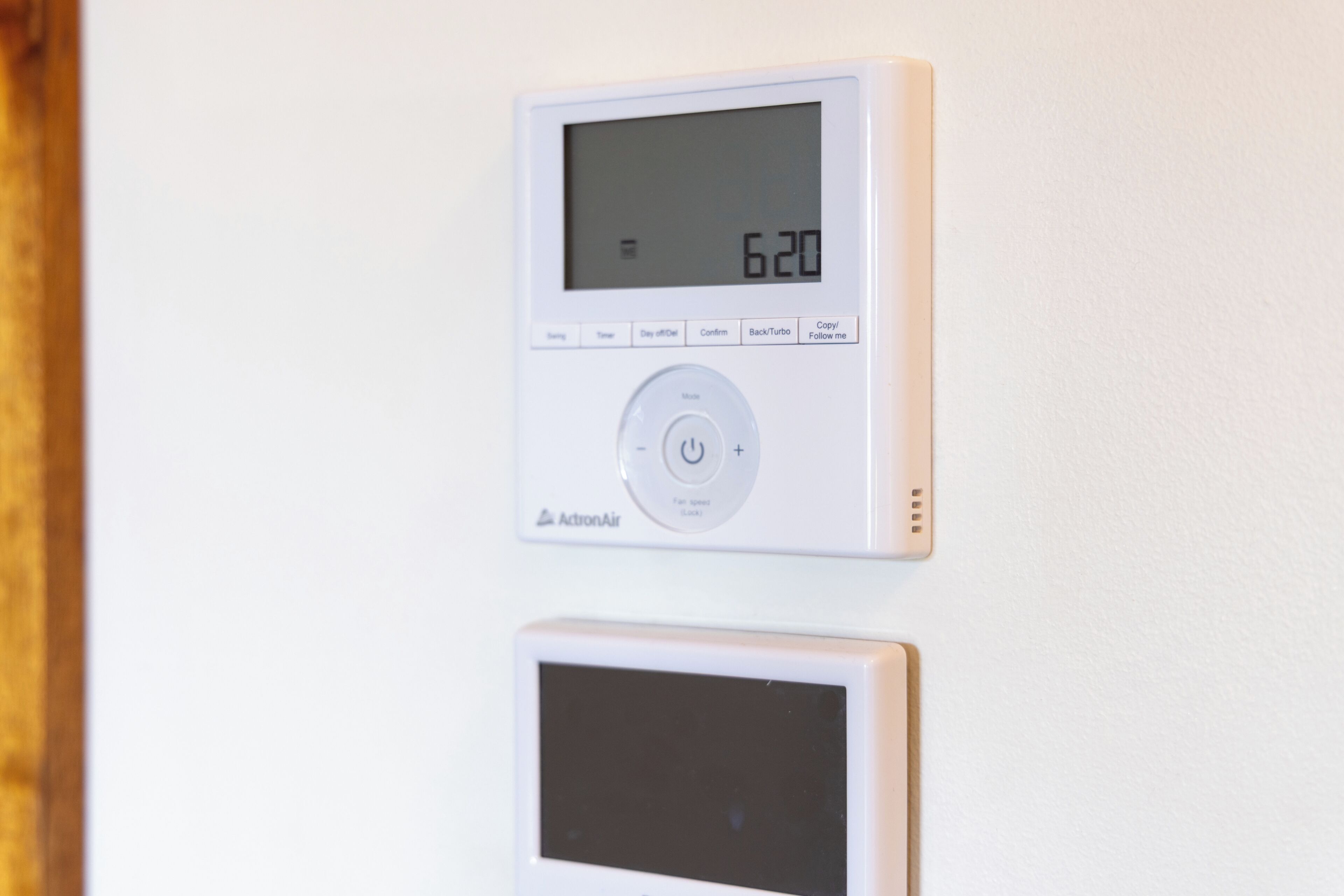 Un termostato con pantalla digital y botones de control.