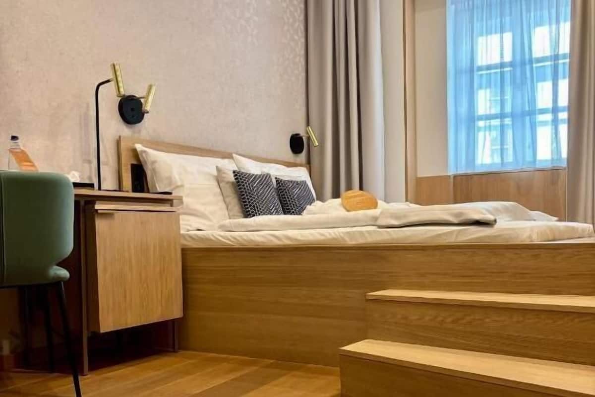 Un dormitorio moderno con una cama de madera, un escritorio y una silla.