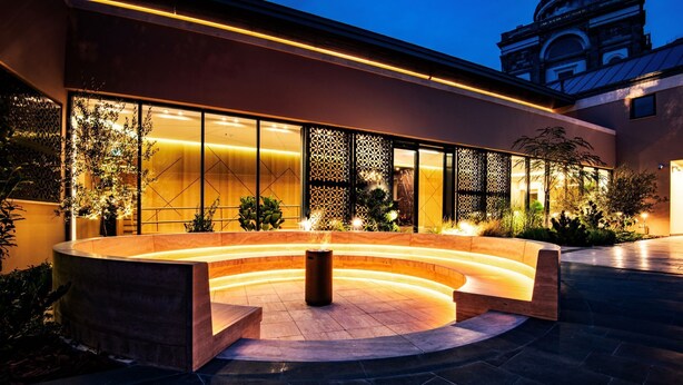 Un edificio moderno con una zona de estar curva, ventanas amplias y paneles decorativos.