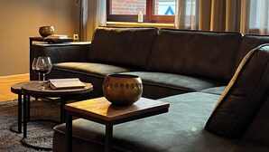 A modern living room with a sofa, a small table, a bowl, and a lamp. - Apartment in Garding with gym (Garding)