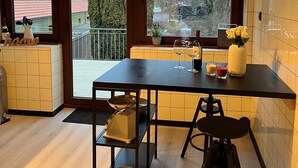 A kitchen with a dining table, chairs, a coffee machine, and a view of the outside. - Apartment in Garding with gym (Garding)