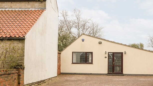 A building with a tiled roof, a single window, and a door. - Millers Retreat (Chesterfield)