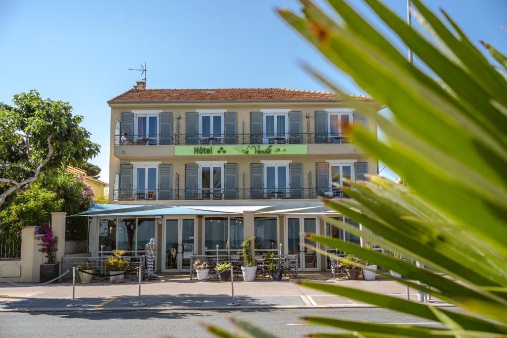 Un hôtel doté d’un balcon, de sièges en plein air et d’une enseigne indiquant qu’il s’agit d’un hôtel.
