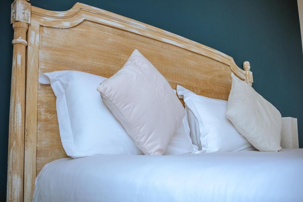 A bed with a wooden headboard and white bedding.