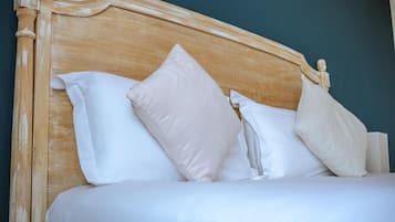 Een bed met een houten hoofdeinde en witte beddengoed.