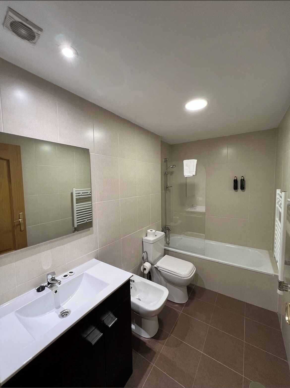 A modern bathroom with a bathtub, toilet, and sink.