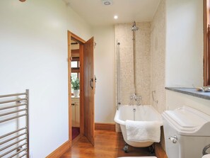 A bathroom with a bathtub, a toilet, and a shower. - Jolly Crabber (St Austell)