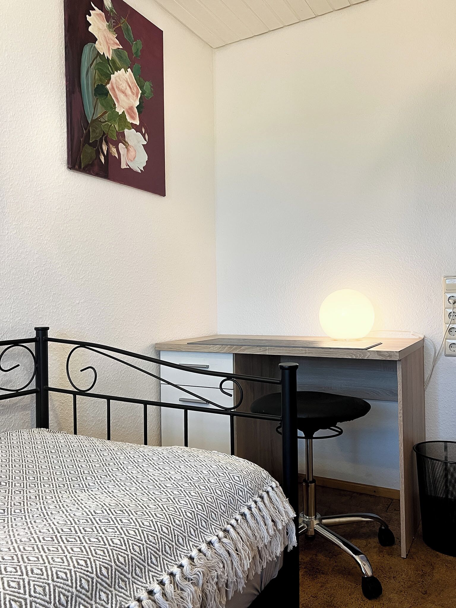 Un dormitorio con cama, escritorio y silla.