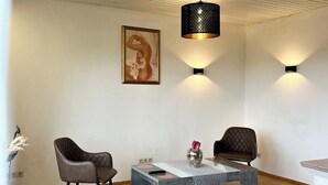 Uma sala de estar moderna com um sofá, uma mesa de centro, um vaso decorativo e um quadro na parede.