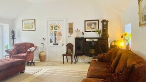 Un salon avec une cheminée, une porte dotée d’une fenêtre et une horloge au mur.