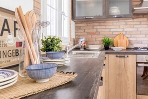 A kitchen with a brick wall, stainless steel appliances, and a wooden cabinet. - Easylife - Bobbio - Charming villa with parking (Bobbio)