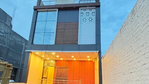 Un edificio moderno con un letrero que dice 'R.K. Palace', que cuenta con una escalera, una entrada con portones y un cielo despejado.